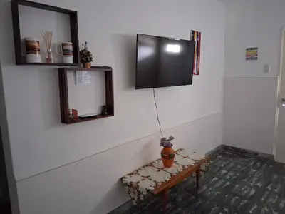 a room with a table and a tv on the wall at Almafuerte Alquiler Temporario in Almafuerte