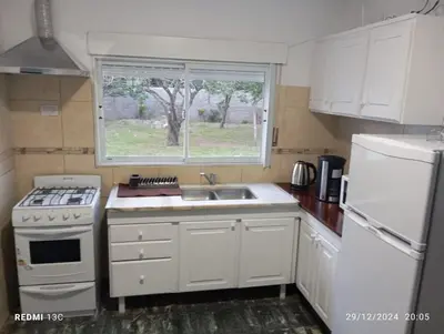 a kitchen with a stove and a sink and a window at Almafuerte Alquiler Temporario in Almafuerte
