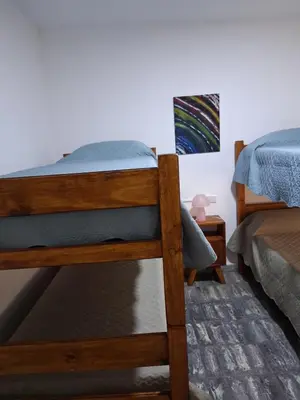a bedroom with two bunk beds and a painting on the wall at Almafuerte Alquiler Temporario in Almafuerte