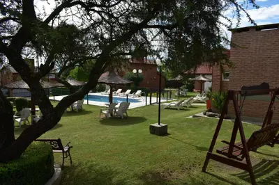 a yard with a pool with chairs and a tree at Apartments Fazenda Solares in San Antonio de Arredondo
