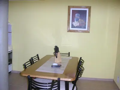 a dining room table with chairs and a picture on the wall at Apartments Fazenda Solares in San Antonio de Arredondo