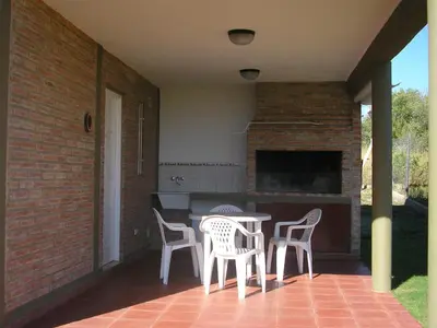 a patio with chairs and a table and a fireplace at Apartments Fazenda Solares in San Antonio de Arredondo
