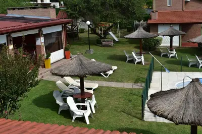 a patio with a table and chairs and umbrellas at Apartments Fazenda Solares in San Antonio de Arredondo