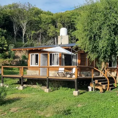 a cabin in the woods with a fence at Cabaña Cielos del Champaqui 6 kms VGB in Villa Ciudad Parque