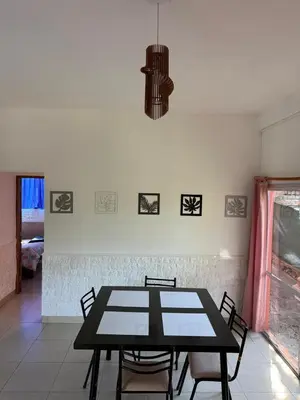 a dining room with a black table and chairs at Cabaña frente al rio solo familias in Villa Carlos Paz