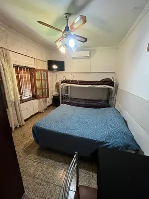 a bedroom with a bed and a ceiling fan at Cabaña ELE en Cabañas María in Villa Carlos Paz