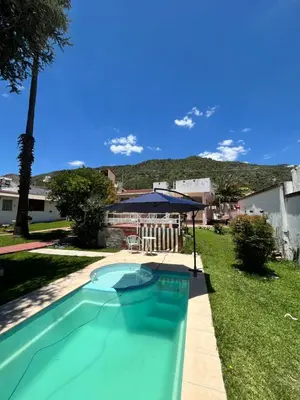 a swimming pool in a yard with a house at Cabaña ELE en Cabañas María in Villa Carlos Paz