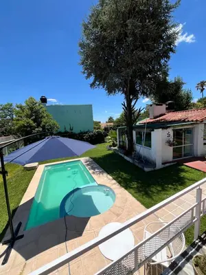 a villa with a swimming pool and a house at Cabaña ELE en Cabañas María in Villa Carlos Paz