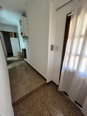 an empty hallway with a white wall and a door at Cabaña ELE en Cabañas María in Villa Carlos Paz