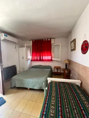 a bedroom with a bed and a red curtain at Cabaña EMI en Cabañas María in Villa Carlos Paz