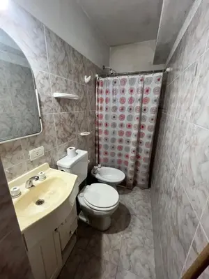 a bathroom with a toilet and a sink and a mirror at Cabaña EMI en Cabañas María in Villa Carlos Paz