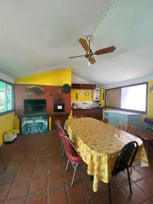 a kitchen with a table with chairs and a ceiling fan at Cabaña EMI en Cabañas María in Villa Carlos Paz