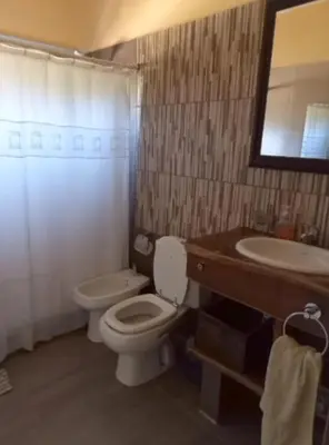 a bathroom with a toilet and a sink at Iwoka Los Aromos in Villa Los Aromos