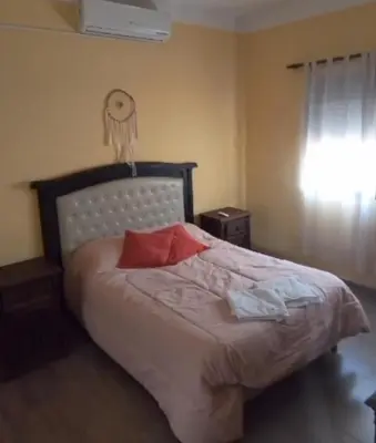 a bedroom with a large bed with two red pillows at Iwoka Los Aromos in Villa Los Aromos