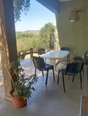 a patio with a white table and chairs and a table and chairs at Iwoka Los Aromos in Villa Los Aromos