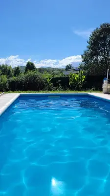 a blue swimming pool with mountains in the background at Iwoka Los Aromos in Villa Los Aromos