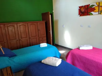 two beds in a room with pink and blue at Complejo Aguas Calmas - Casa Laguna in Los Reartes