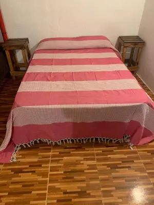 a bed with a red and white blanket on the floor at Monarcas II in Villa Carlos Paz