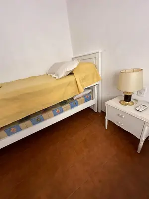 a bedroom with a bed and a table with a lamp at Hermosa Casa en el Centro, con Cochera in Villa Carlos Paz