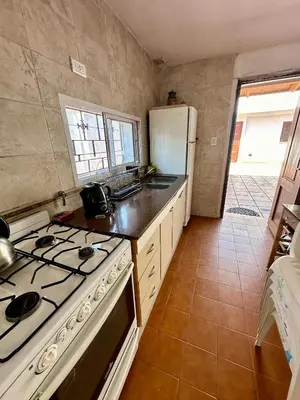 a kitchen with a stove and a refrigerator at Hermosa Casa en el Centro, con Cochera in Villa Carlos Paz