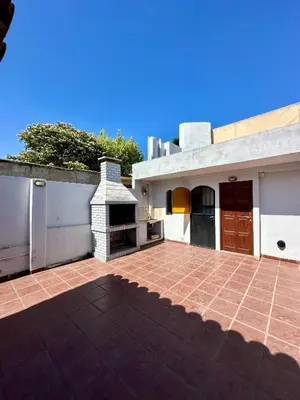 a house with a brick patio and a fireplace at Hermosa Casa en el Centro, con Cochera in Villa Carlos Paz