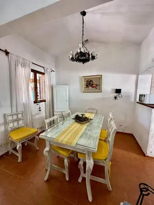 a dining room with a table and chairs and a chandelier at Hermosa Casa en el Centro, con Cochera in Villa Carlos Paz