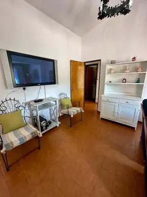 a living room with two chairs and a flat screen tv at Hermosa Casa en el Centro, con Cochera in Villa Carlos Paz
