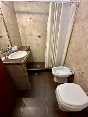 a bathroom with a toilet and a sink and a shower at Hermosa Casa en el Centro, con Cochera in Villa Carlos Paz