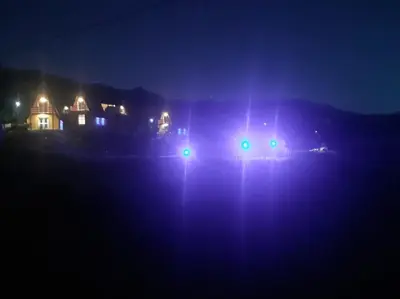 a car with green lights in the dark at Complejo Habitacional RLM 25 in Cortaderas