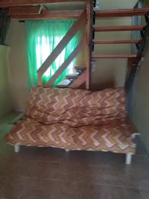 a couch sitting in a room next to a staircase at Complejo Habitacional RLM 25 in Cortaderas