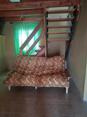 a couch sitting in a room with a staircase at Complejo Habitacional RLM 25 in Cortaderas