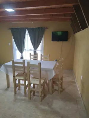 a dining room with a white table and chairs at Complejo Habitacional RLM 25 in Cortaderas