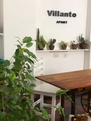 a table with potted plants on a shelf with a sign at Villanto apart Solo Adultos in Mina Clavero