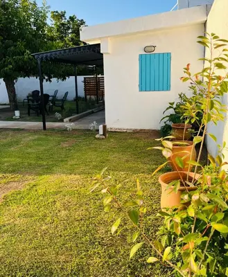 a house with a blue window and some plants at Villanto apart Solo Adultos in Mina Clavero