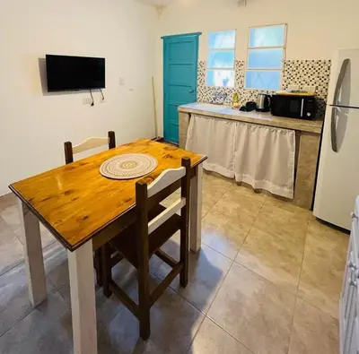 a kitchen with a wooden table and a refrigerator at Villanto apart Solo Adultos in Mina Clavero
