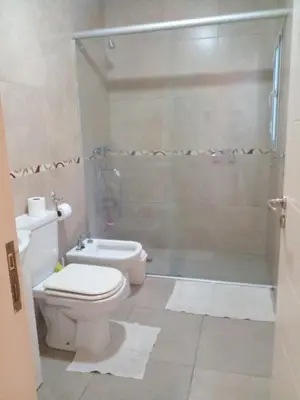 a bathroom with a toilet and a glass shower at Casa en Lomas del Rey - Mayu Sumaj in San Antonio de Arredondo