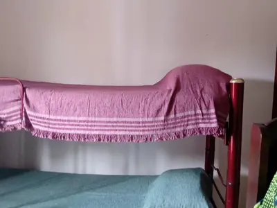 a bed with a pink blanket on top of it at Sierras nuestras in Mina Clavero