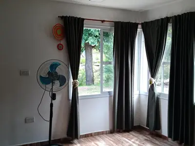 a fan in a room with a window at Sierras nuestras in Mina Clavero