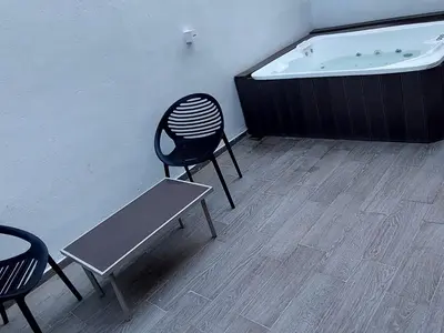a chair and a bench next to a bath tub at departamento boutique centrico- villa carlos paz in Villa Carlos Paz