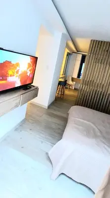 a bedroom with a bed and a flat screen tv at departamento boutique centrico- villa carlos paz in Villa Carlos Paz
