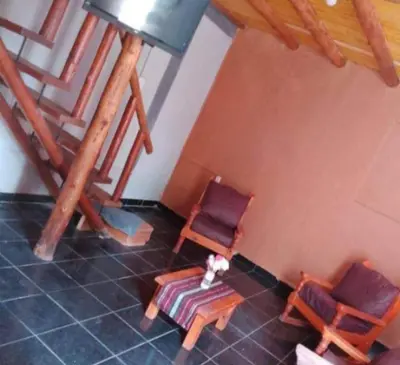 a room with two chairs and a table and stairs at cabaña rustica in Bialet Massé