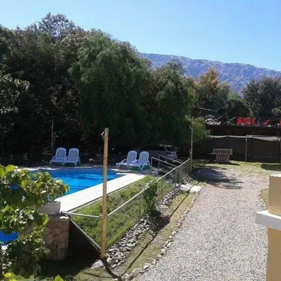 a swimming pool with two lawn chairs next to it at Tierra del Sol in Merlo