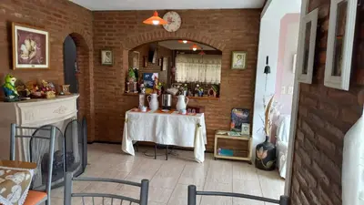 a dining room with a table and a brick wall at Tierra del Sol in Merlo