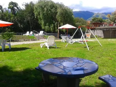 a table in a yard with chairs and a swing at Tierra del Sol in Merlo