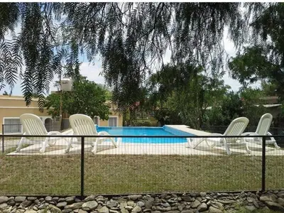 a group of white chairs sitting next to a pool at Tierra del Sol in Merlo