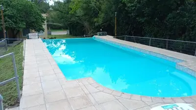 a large blue swimming pool with a staircase around it at Tierra del Sol in Merlo