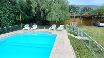 a swimming pool with lounge chairs next to a fence at Tierra del Sol in Merlo