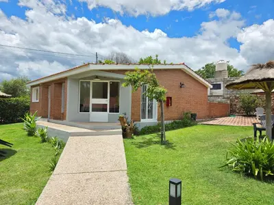 a small brick house with a grass yard at La Margarita Aparts - Solo 2 Pax in Mina Clavero