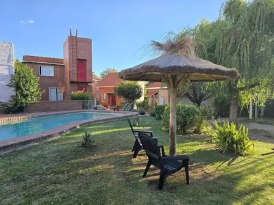 two black chairs and an umbrella in a yard at La Margarita Aparts - Solo 2 Pax in Mina Clavero