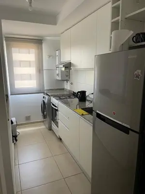 a kitchen with white cabinets and a stainless steel refrigerator at Depto 2 Dormitorios Pilay F Temporario in Cordoba